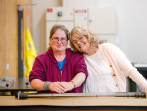 Two women embracing and smiling together indoors